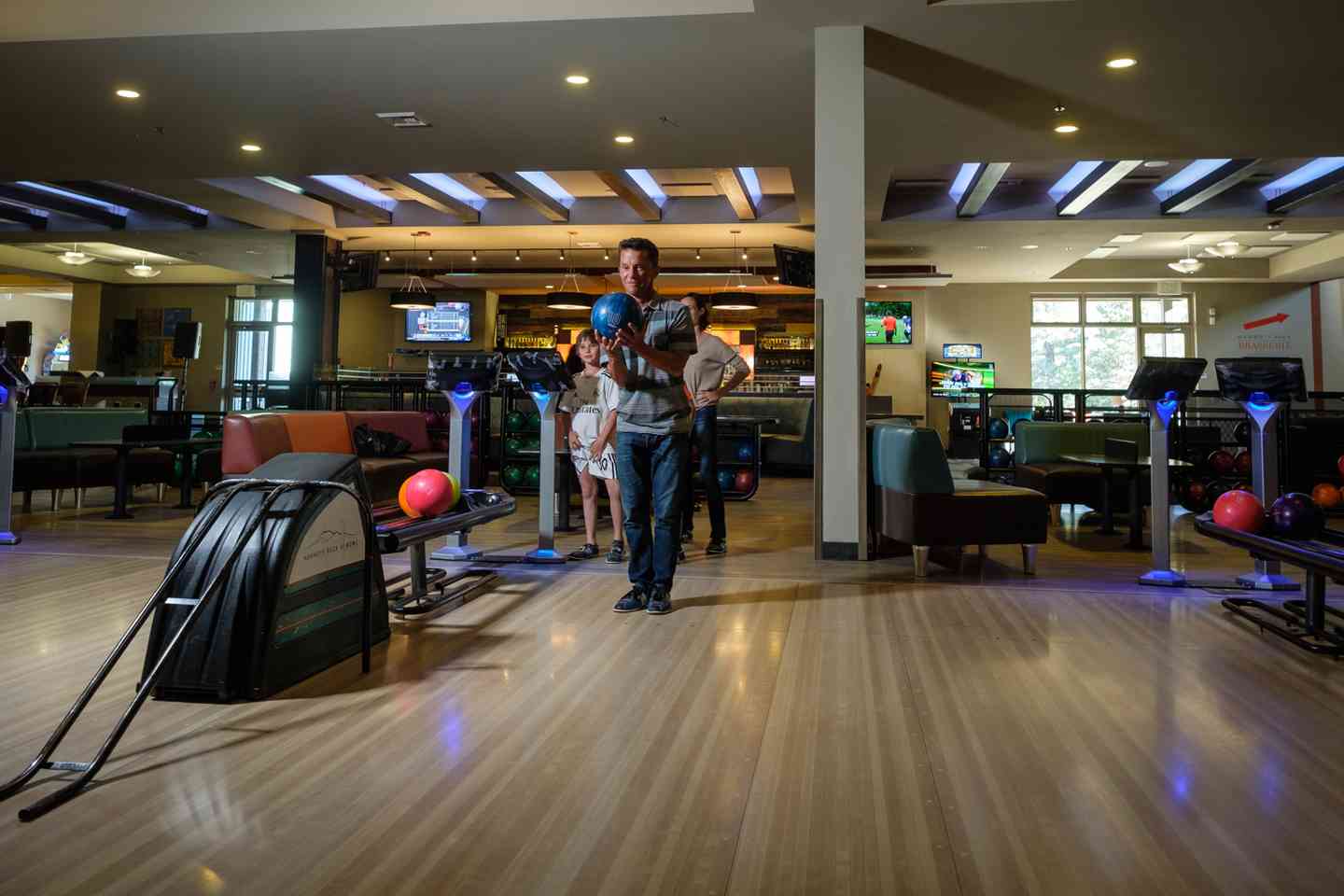 Picture of a main about to throw a bowling ball down a lane