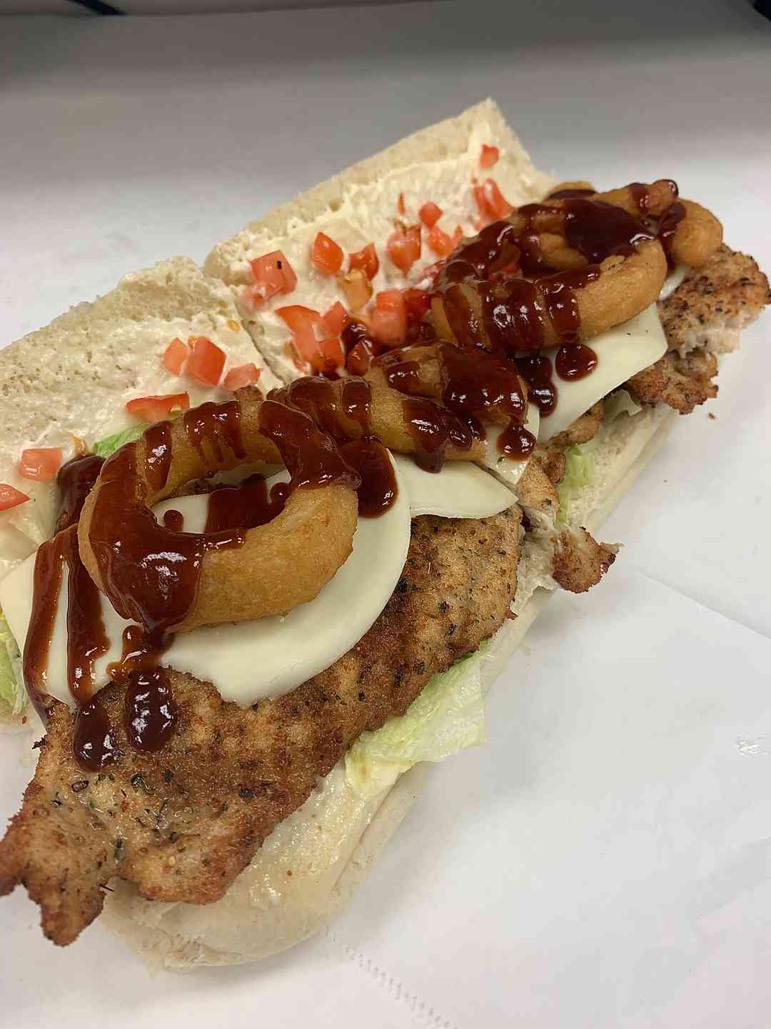 sandwich with onion rings and barbecue sauce