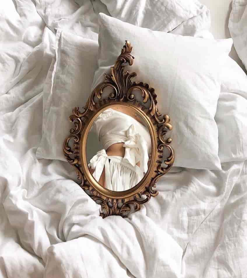 Mirror on bed reflecting girl's body
