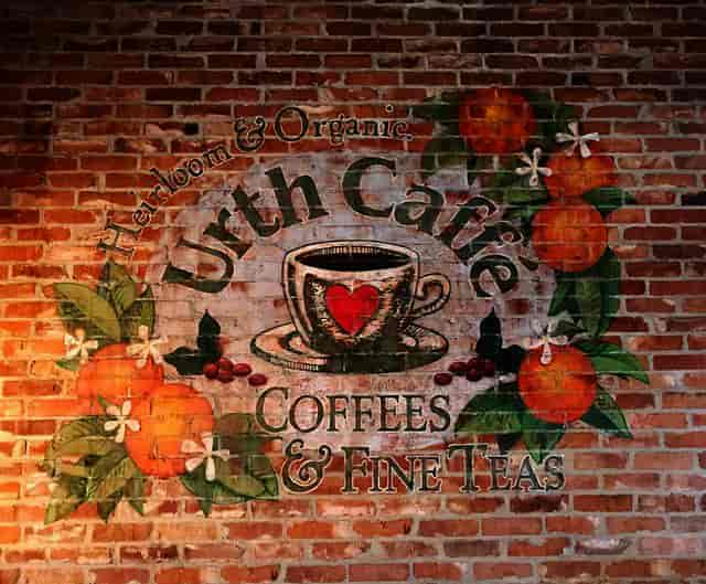Urth Caffe Orange rustic logo painted on brick wall