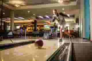 Kid throwing a bowling ball down a lane