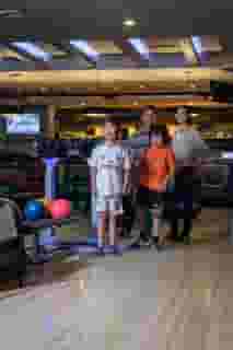 Family posing for a photo while playing a game of bowling