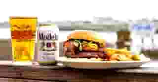 Burger with fries and a Modelo beer and a beer in a Dead Dogs Saloon glass