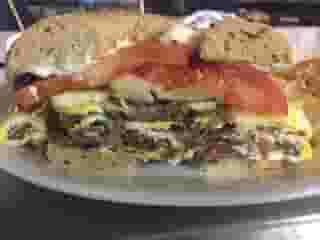 Pastrami and fried egg sandwich on a toasted bagel with melted Swiss