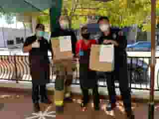 2 Urth Melrose employees with 2 Firemen holding Urth shopping bags and