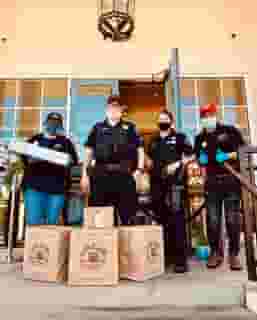 Male and Female Hawthorne Police with two Urth employees on Urth South Bay entrance with Urth bags and lunch boxes