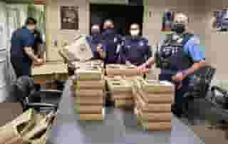 Five Pasadena police standing around conference table stated with Urth Lunch boxes.