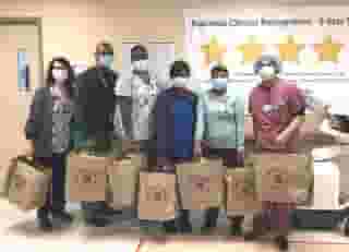 Six nurses in a line holding Urth food bags
