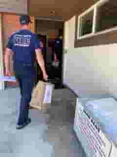 Laguna Beach fireman in t-shirt carrying Urth food bag into station