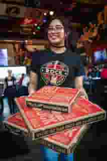 waitress holding pizza boxes
