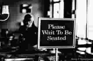 Photo of sign that says please wait to be seated