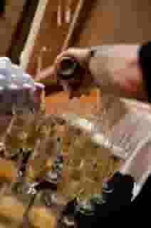 Waiter pouring wine into glasses