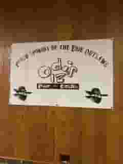 sponsor of eerie outlaws sign posted on wooden wall