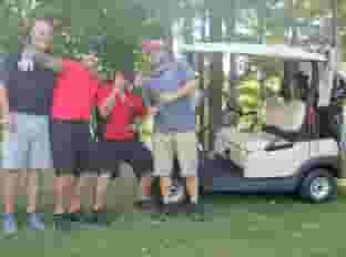four people and golf cart