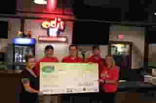 5 people holding a large check