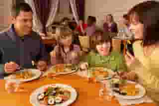 family sitting at table with plates of food