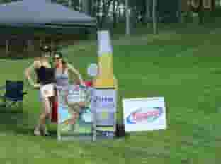 two people on golf course next to beer signs
