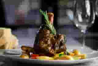 Lamb Shank: Slow braised lamb shank in red wine, garlic and rosemary, served with potatoes and mixed vegetables