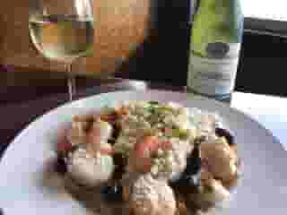 Shrimp dinner with a glass of wine and wine bottle