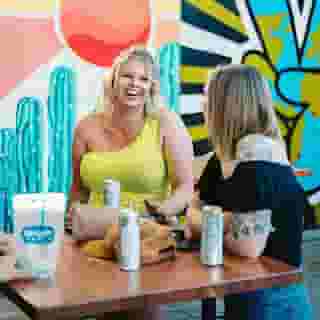 Two women enjoying a conversation over beers
