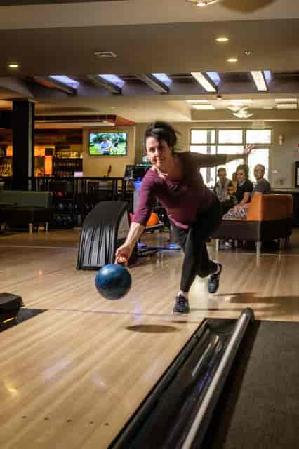 Woman throwing a bowling ball down a lane