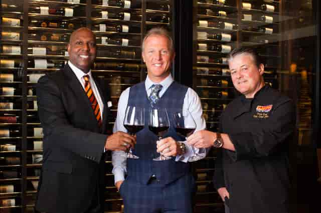 three men holding wine glasses