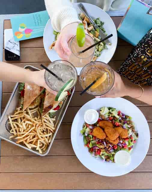 Group toasting with different drinks over multiple dishes