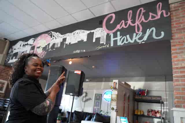 Work with us header image of owner point at Catfish Haven sign