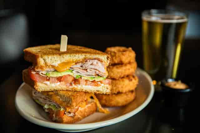 turkey sandwich and onion rings with a beer