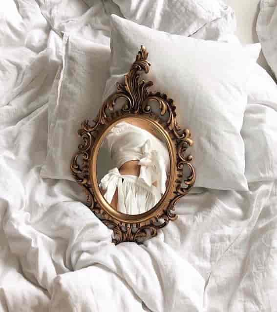 Mirror on bed reflecting girl's body