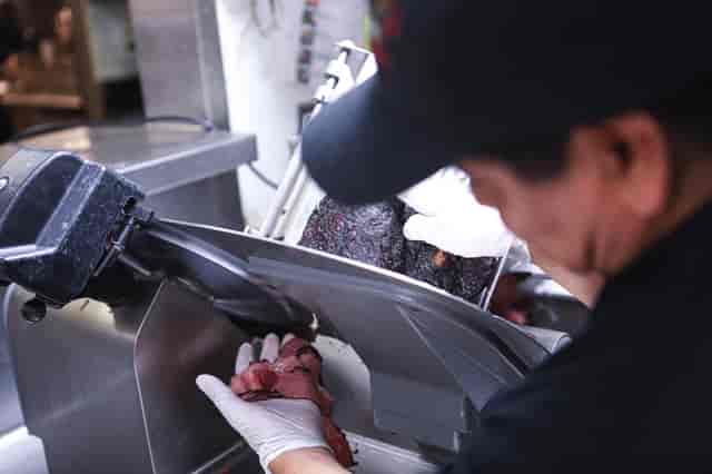 staff shot slicing pastrami