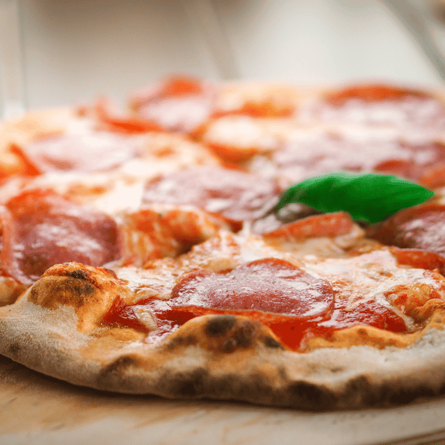 Pizza infront of a brick oven