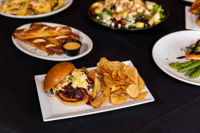 several plates of food including burger, breadsticks, salad