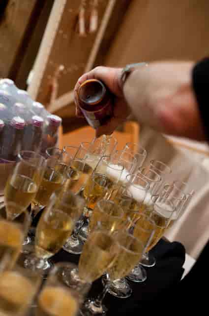 Waiter pouring wine into glasses