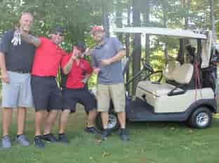 four people and golf cart