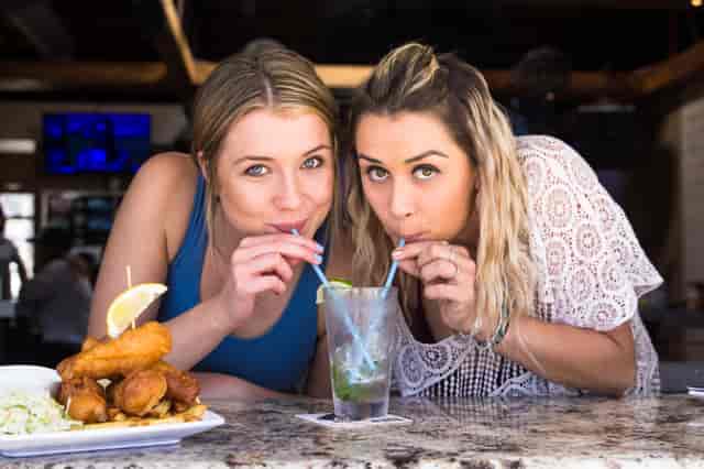 two women drinking with straw