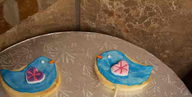 Cookies in the shapes of blue birds with hearts for wings