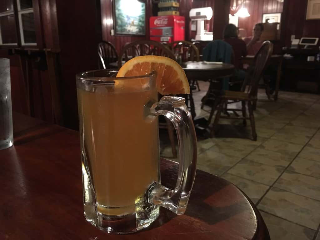beer mug displayed on a table with an orange slice on the rim
