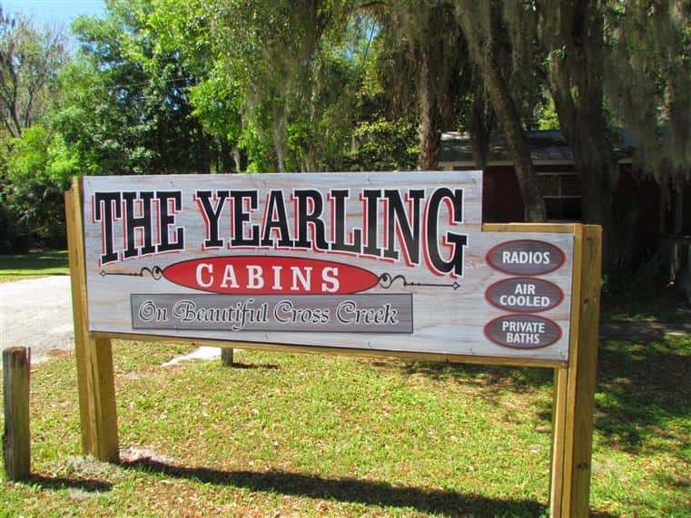 outdoor signage that says "the yearling cabins on beautiful cross creek. Raidos, air cooled and private baths"
