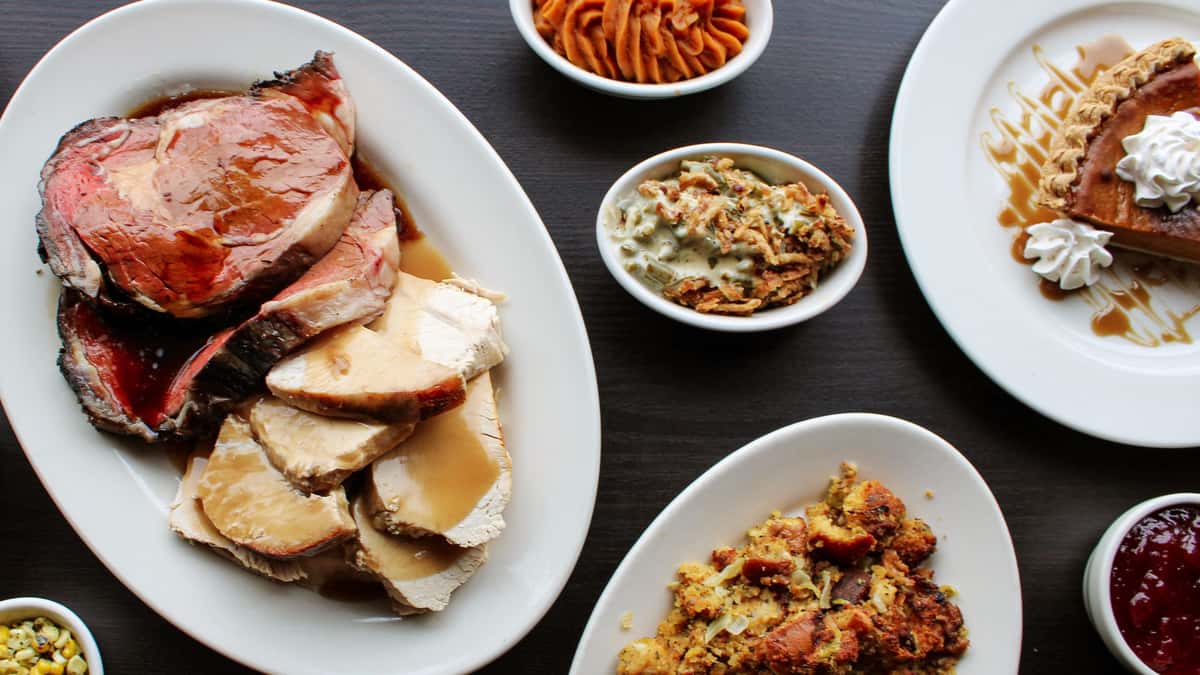 A spread of traditional Thanksgiving foods against a grey backdrop.