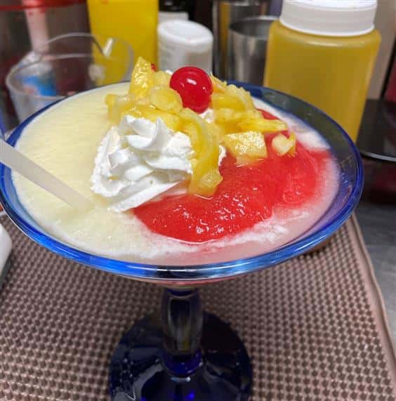 frozen margarita topped with whipped cream and a cherry