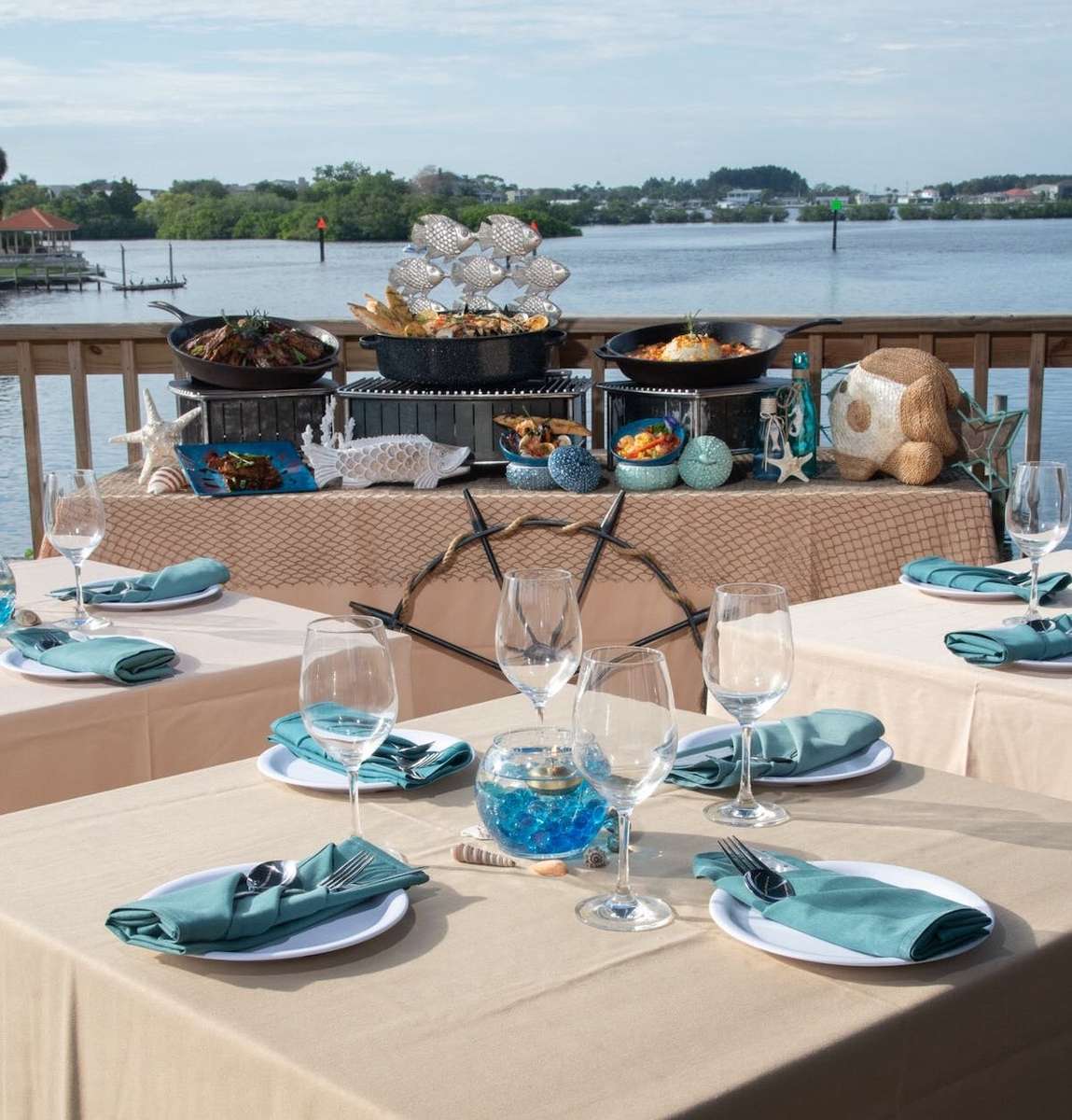 Waterfront seafood buffet station with coastal decor, plated tables, and bay views for a catered private event