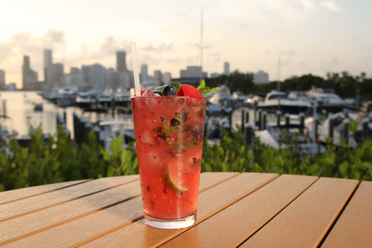 fruity drink on a wooden table with sunset background