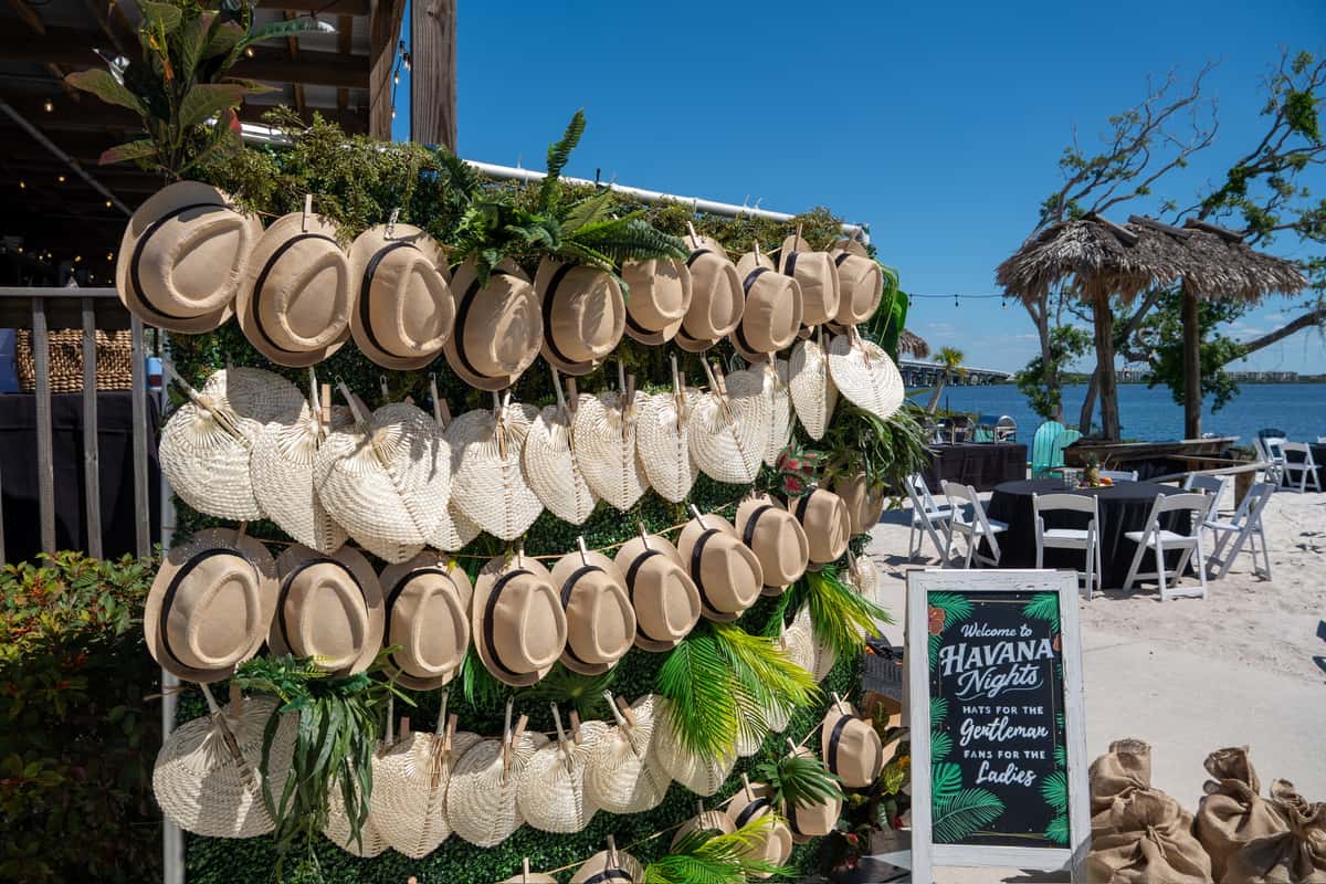 Havana Nights themed party entrance display with straw hats, woven fans, and tropical beachside decor