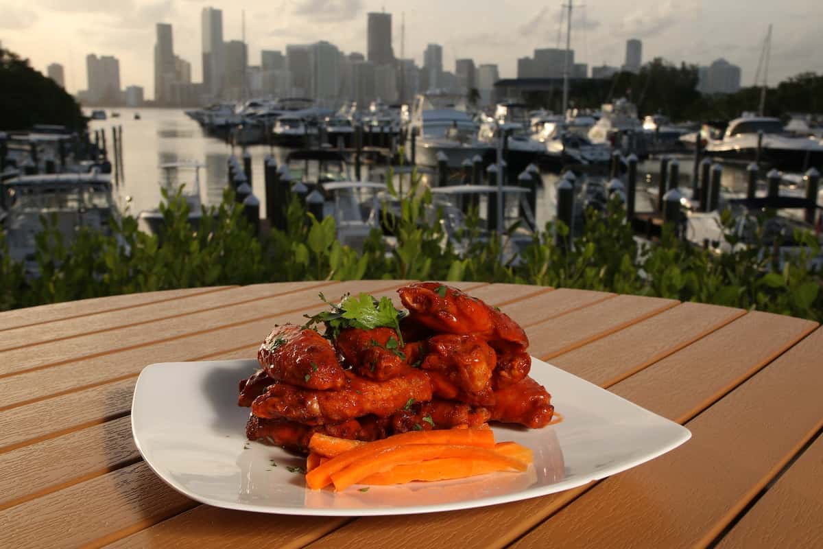 a plate of wings with a view of the city in the background