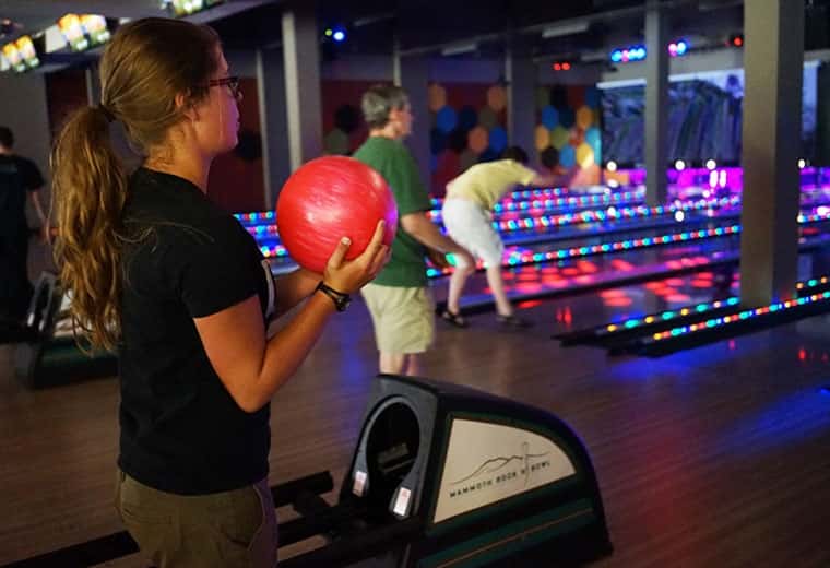 Girl holding a pink bowling ball during cosmic bowling