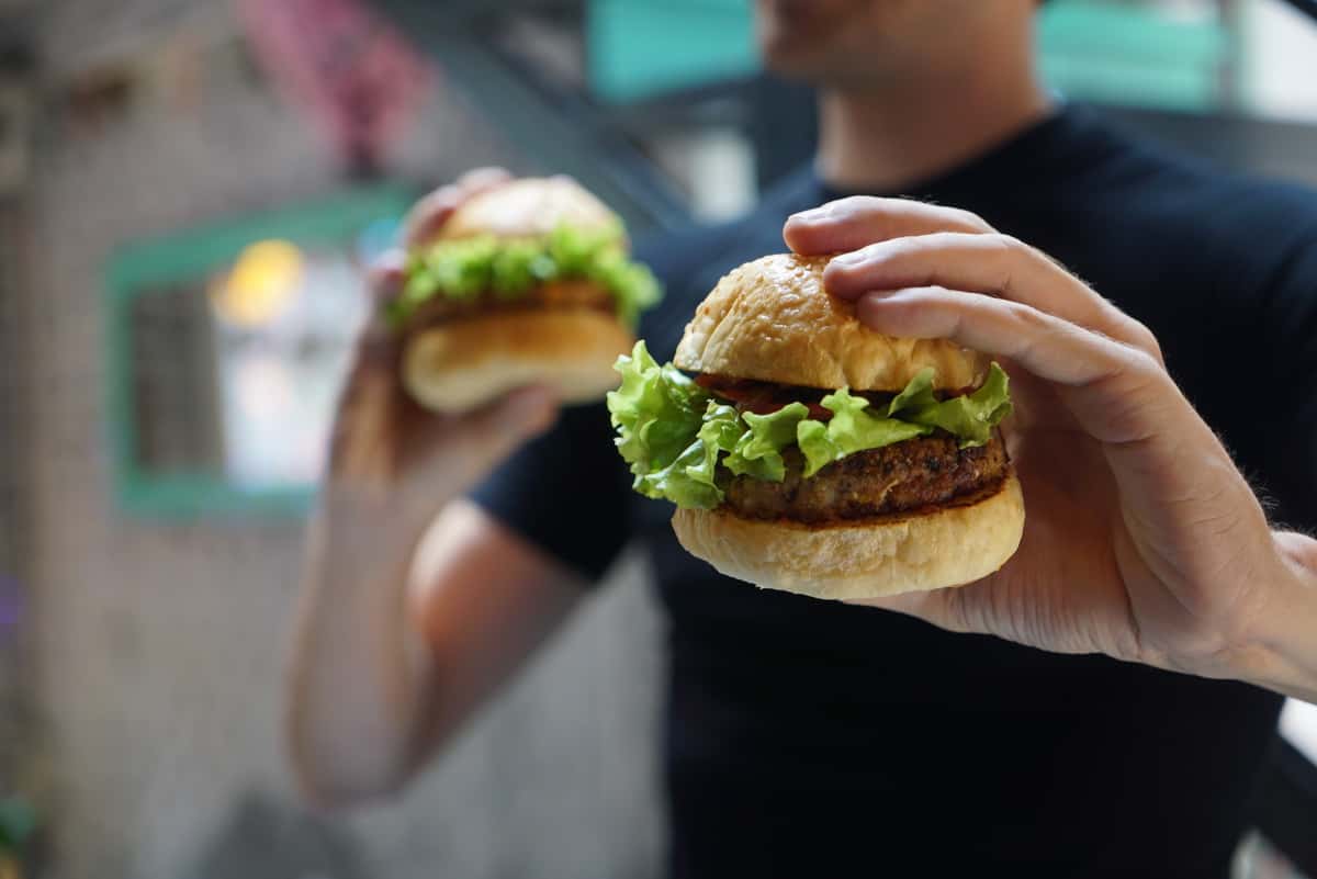 person holding small burgers