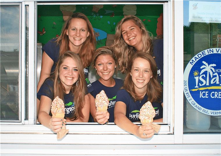 employees smiling with three holding ice cream cones