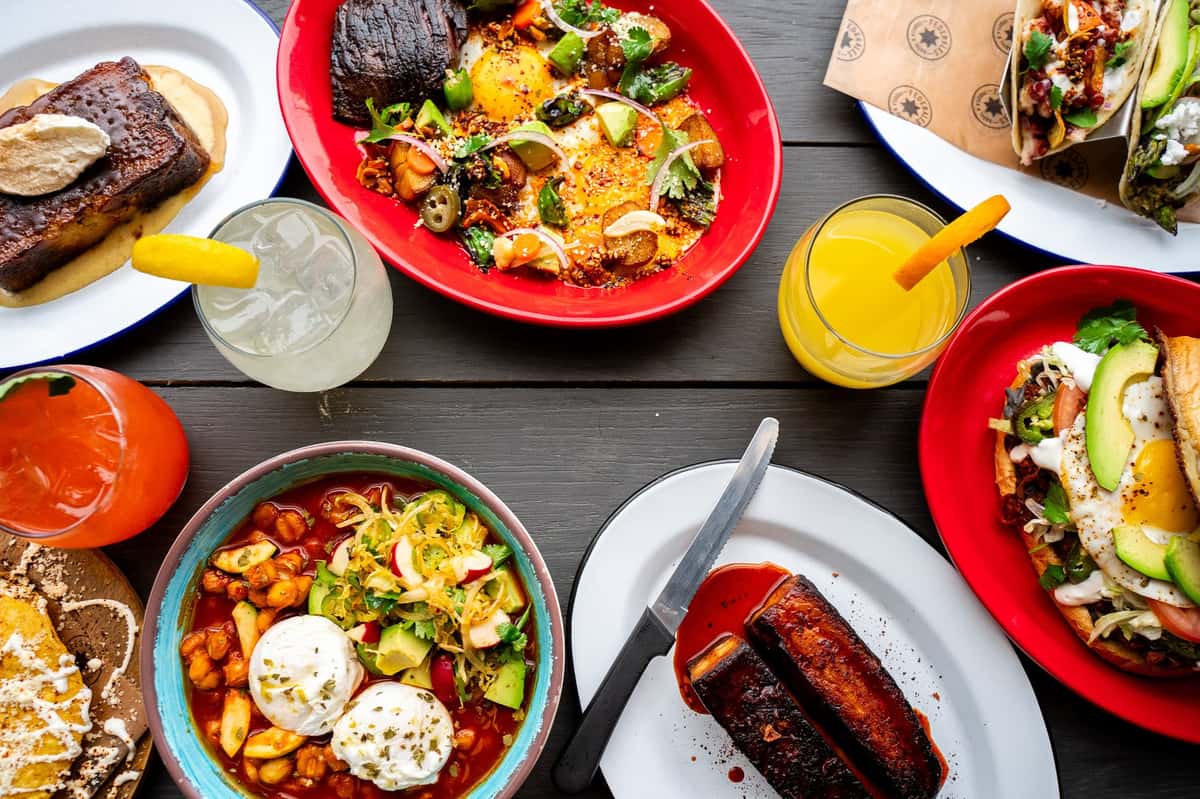 spread of tacos, mimosas, and cocktails on a table