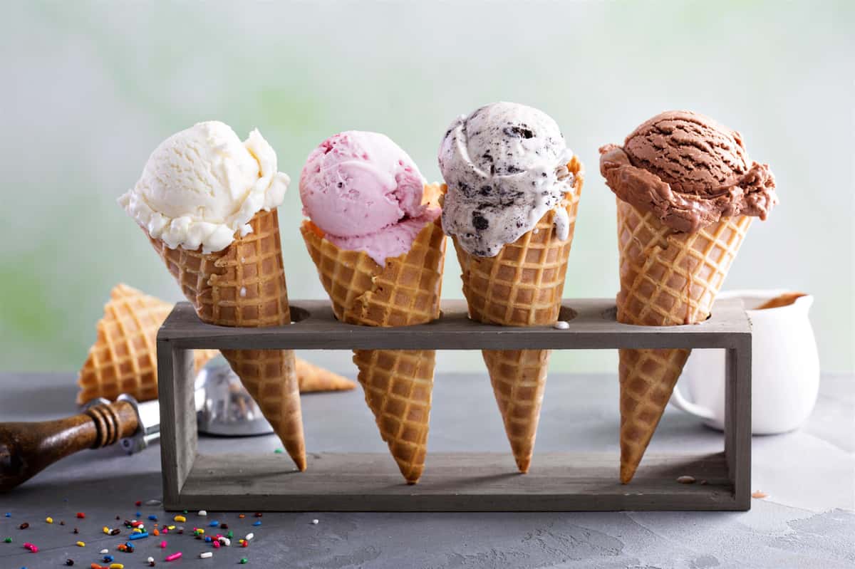 Assorted flavors of ice cream on cones placed in a cone holder